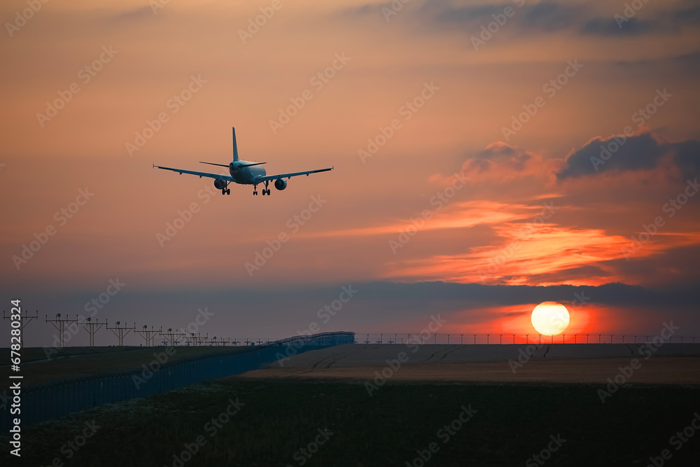 Airplane landing on airport runway at beautiful sunset. Themes travel and aviation.. - obrazy, fototapety, plakaty 