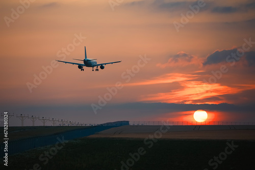 Airplane landing on airport runway at beautiful sunset. Themes travel and aviation..
