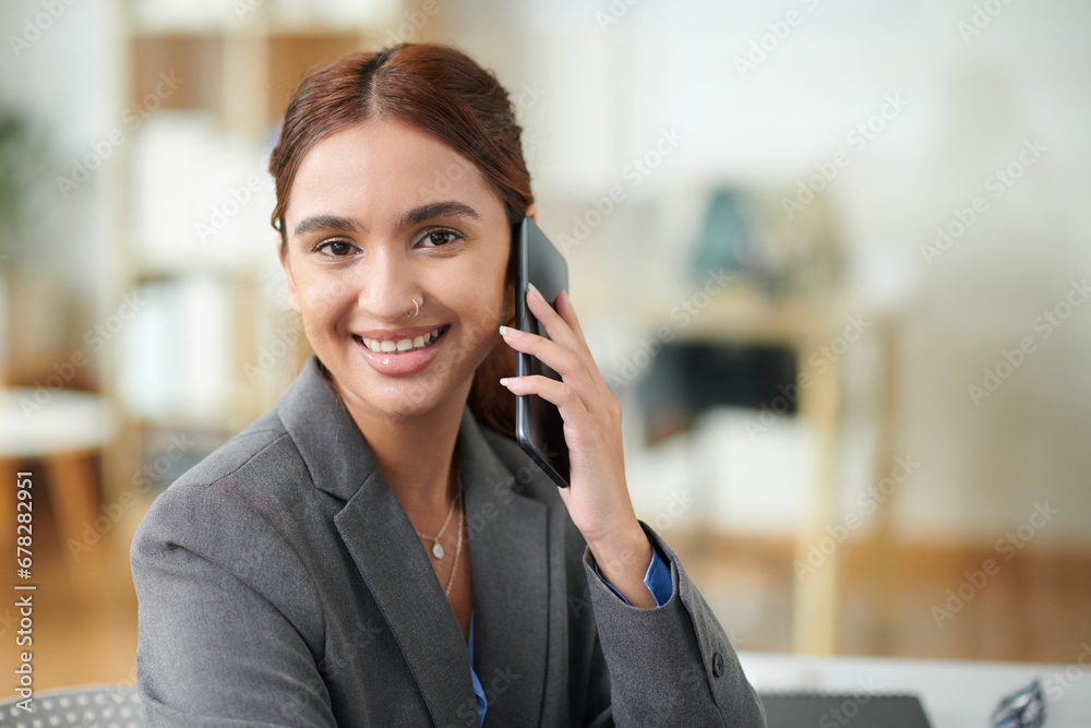 Portrait of cheerful young businesswoman talking on phone when working in office Portrait of cheerful young businesswoman talking on phone when working in office