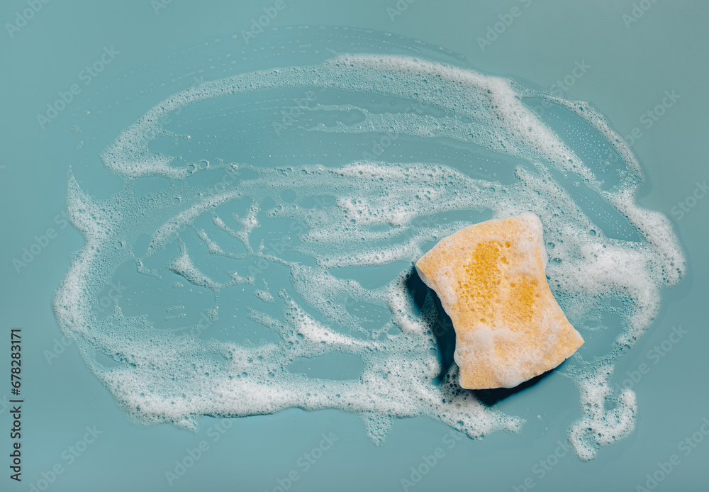 cleaning sponge wiping foam soap suds on blue background, household washing concept - obrazy, fototapety, plakaty 