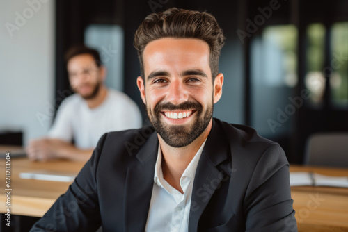 Smiling man sitting at table in meeting room. Perfect for business presentations and team discussions
