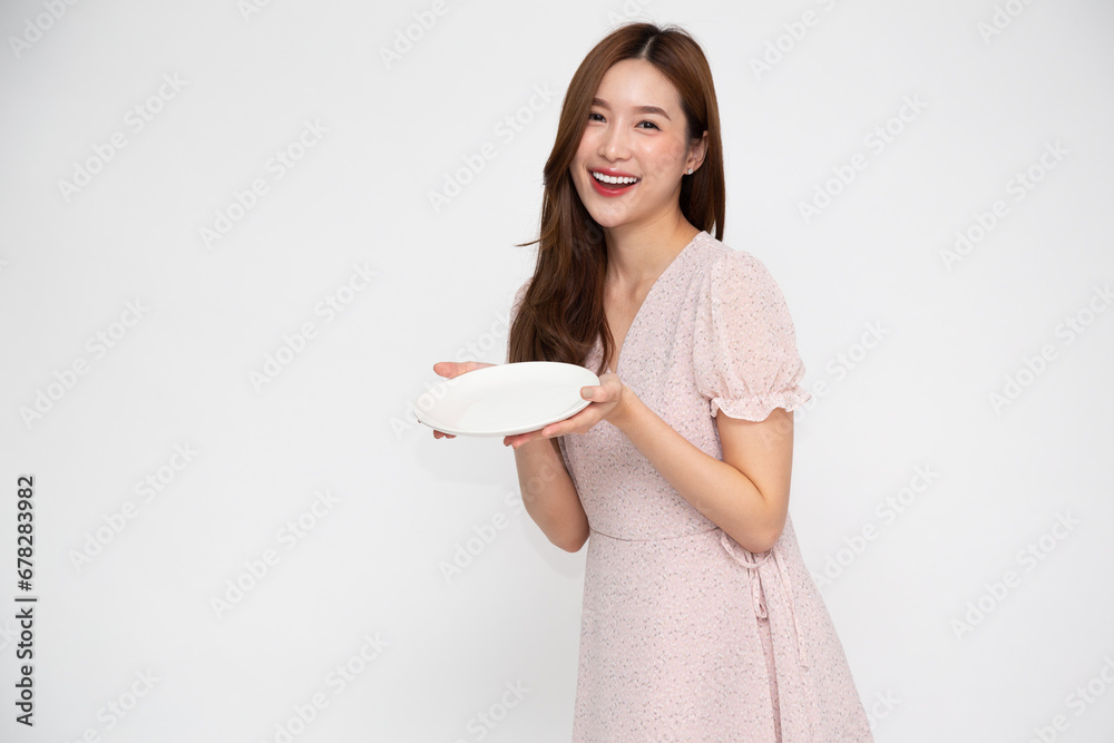 Young Asian woman holding empty white plate or dish isolated on white background Young Asian woman holding empty white plate or dish isolated on white background