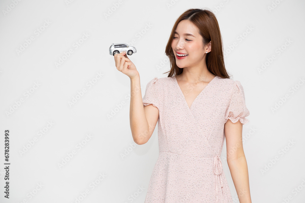 Young Asian woman holding car model isolated on white background, Travel and Motor Insurance concept Young Asian woman holding car model isolated on white background, Travel and Motor Insurance concept