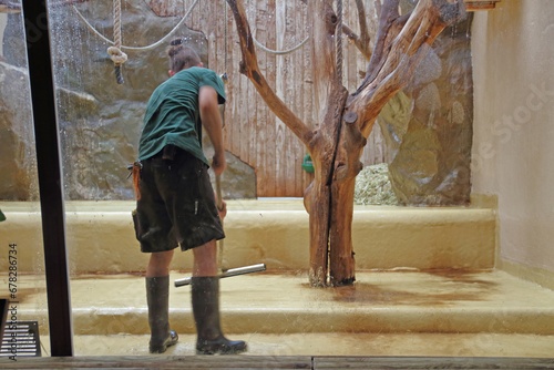 Fotografia Animal keeper cleans an animal enclosure