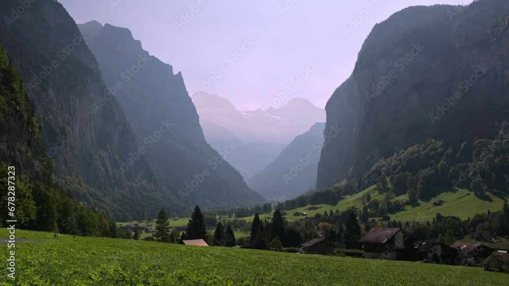 Static view looking through the valley in Lauterbrunnen Switzerland of the mountain layers on hazy day.