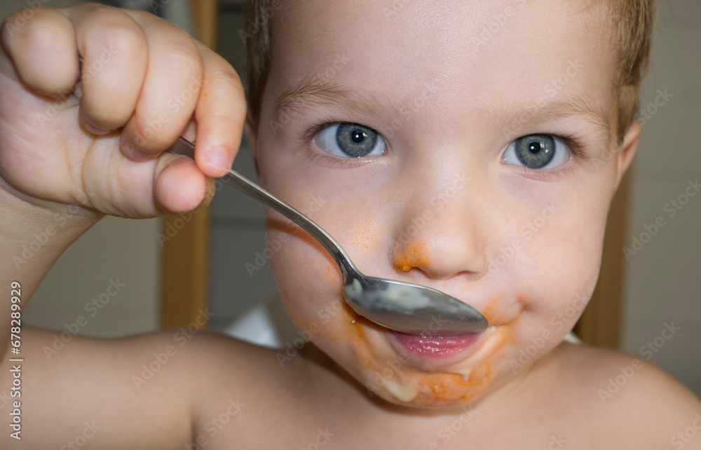 Baby boy eating by himself with spoo Baby boy eating by himself with spoo
