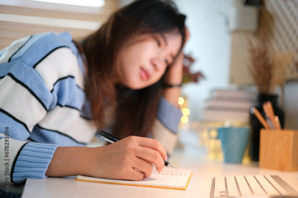 Image of an Asian woman who is tired and overthinking from working with a tablet at the office Image of an Asian woman who is tired and overthinking from working with a tablet at the office