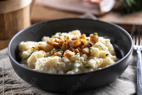 Halusky as traditional Slovak potato gnocchi with sheep cheese bryndza, fried bacon and chives photo