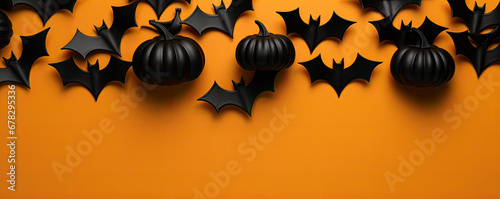 Black bats on orange background. hollween concept. photo