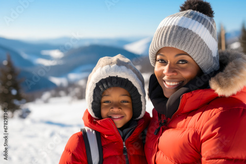 Happy African American mother with son smiling at a ski resort in winter clothes view of mountains and snow in the background winter snow