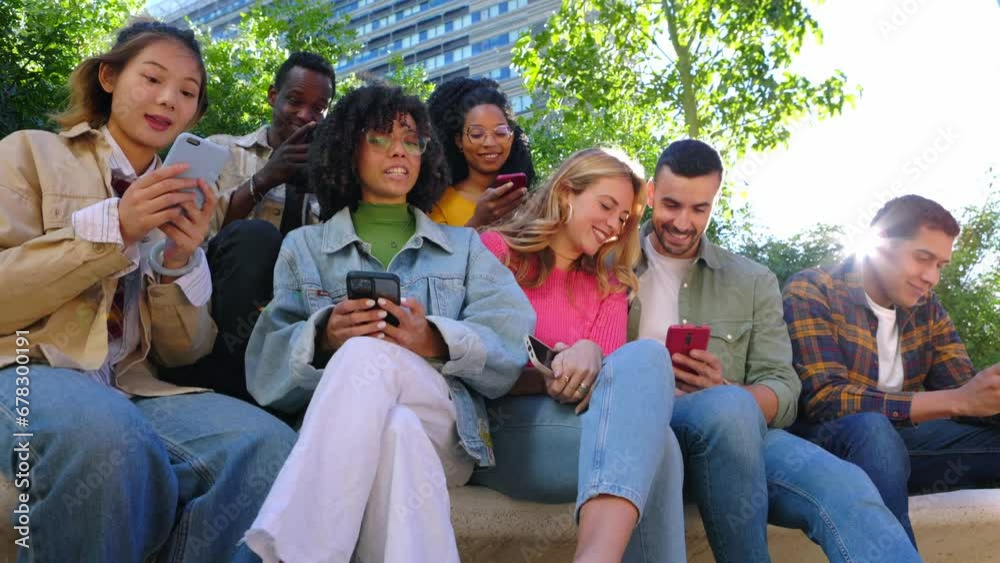 Young group of happy people having fun using mobile phone at city street. Smiling multiracial friends sitting together outside watching social media content on cellphone app. Gen tech people concept Young group of happy people having fun using mobile phone at city street. Smiling multiracial friends sitting together outside watching social media content on cellphone app. Gen tech people concept