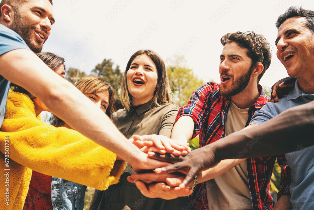 Group of friends with hands together in a show of unity and teamwork, celebrating community and collaboration outdoors. - obrazy, fototapety, plakaty 