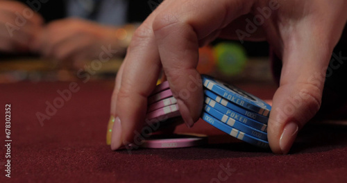Close up of a woman's hand playing poker in a casino.