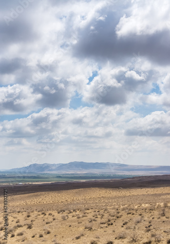 Panoramic view of a mountain range in the desert in cloudy summer weather