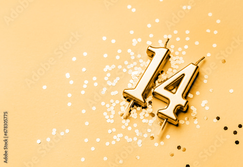 14 years celebration festive background made with golden candle in the form of number Fourteen lying on sparkles. Universal holiday banner with copy space.