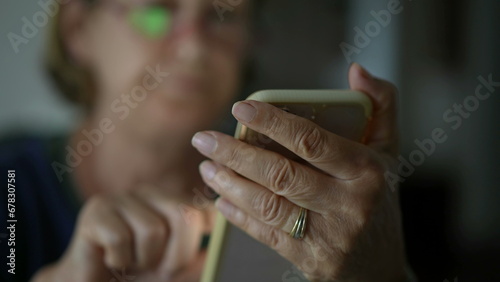 Close-up senior woman hand holding phone messaging with modern technology. Older lady texting with smartphone