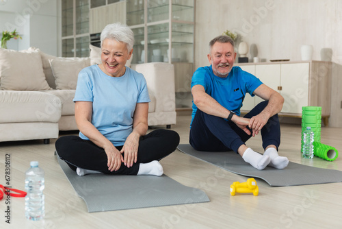 Fitness workout training. Senior adult mature healthy fit couple doing sports exercise on yoga mat on floor at home. Mid age old husband wife have training workout. Health care healthy lifestyle