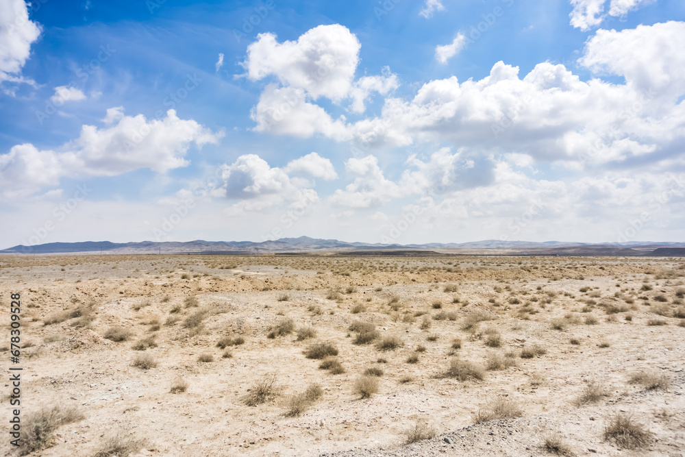 Panoramic view of a mountain range in the desert in cloudy summer weather