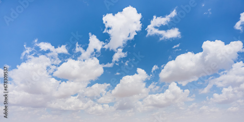 Minimalistic panorama of sky with cumulus clouds on a sunny summer day © Denis