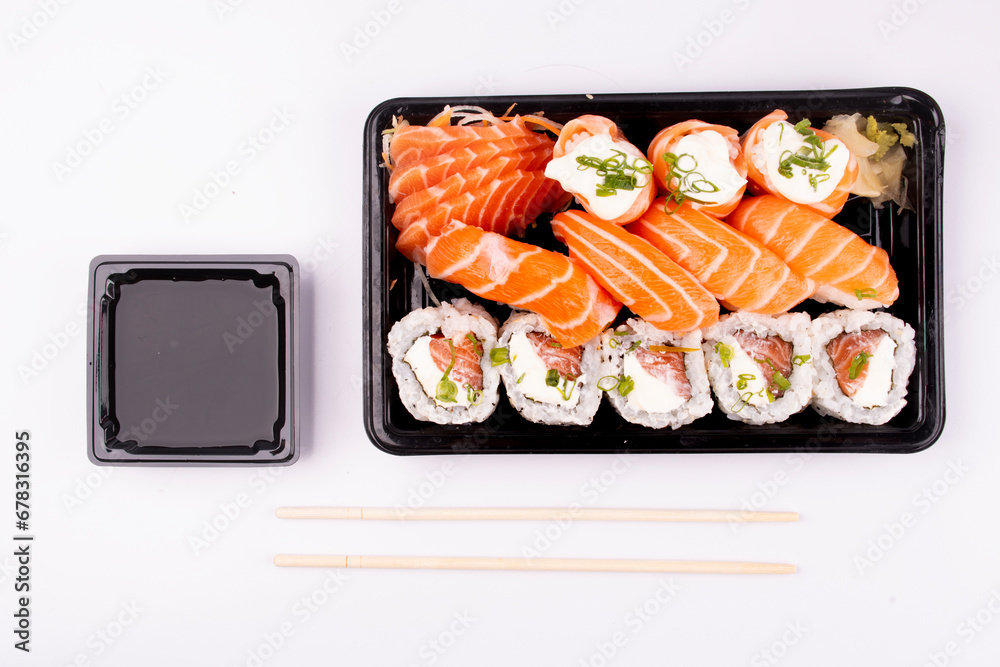 japanese food sushi delivery isolated on background top view on white background with chopsticks and soy sauce