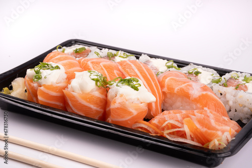 sushi delivery tray isolated on white background with chopsticks in close-up