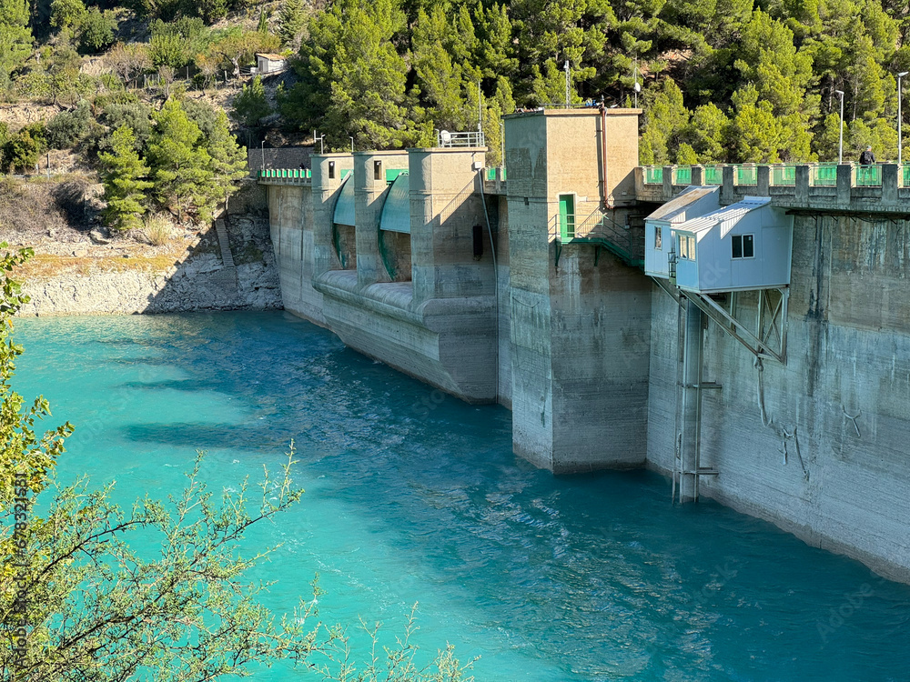 Panoramic view of a dam in a reservoir, in Guadalest village, Spain. The floodgates are open. Panoramic view of a dam in a reservoir, in Guadalest village, Spain. The floodgates are open.