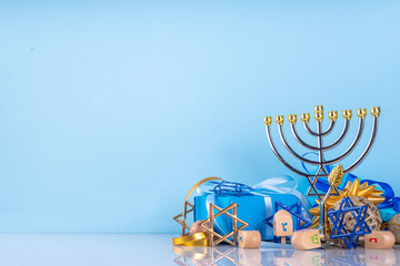 Happy Hanukkah greeting card background. Jewish New Year holiday flat lay with traditional symbols of hanukkah festival, menorah, donuts and decorations copy space