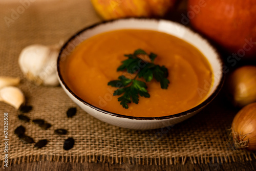 A bowl of pumpkin soup with vegetables on the table.Rustic autumn food.Diet soup