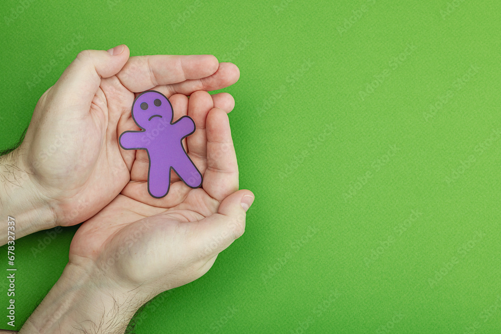 World mental health day. Male hands holding paper men figures with different emotions World mental health day. Male hands holding paper men figures with different emotions