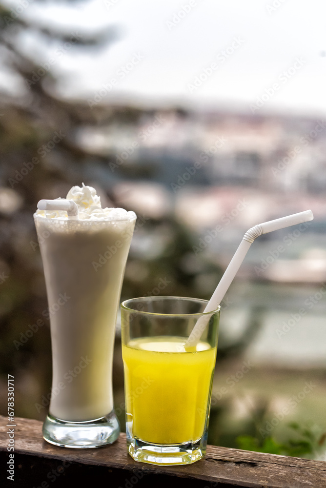 A chocolate-flavored milkshake with a side of lemonade stands next to it
