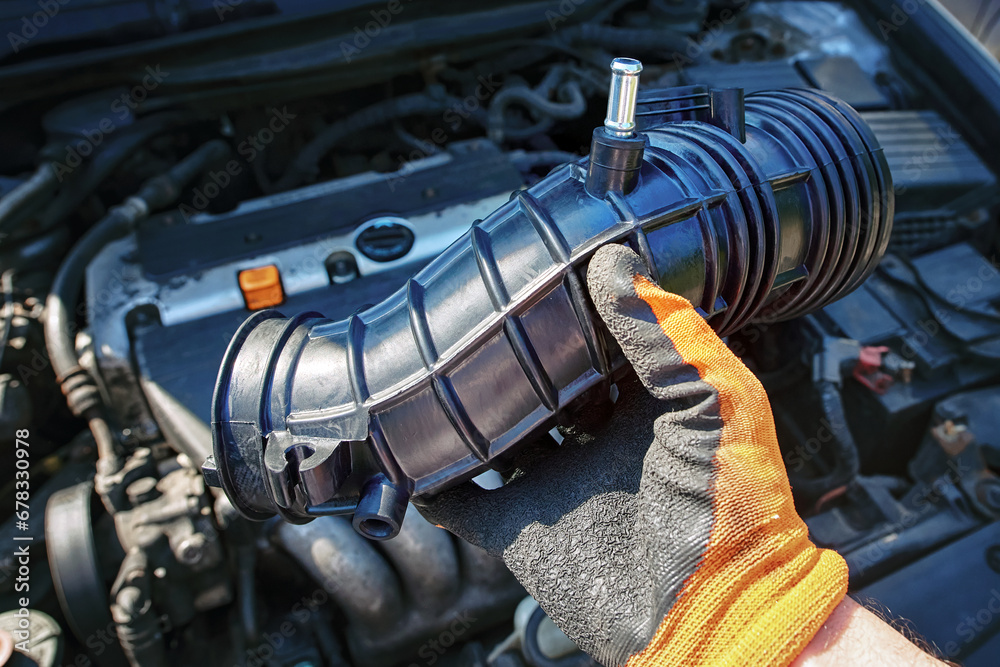 Air intake hose replacement, new spare parts. Air intake hose repair, fixing problems. New rubber tube. Car engine repair..