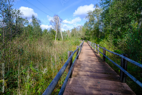 A wooden bridge  a path with a railing as a place for tourists to walk to a difficult environment in Latvia.