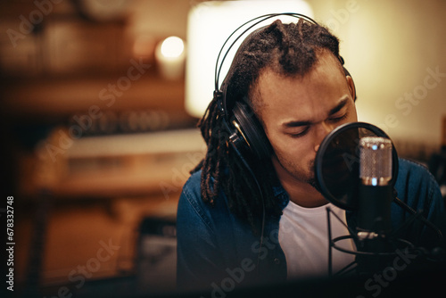 Young singer laying down songs in a recording studio photo