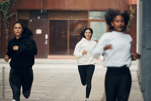 Smiling woman running with friends photo