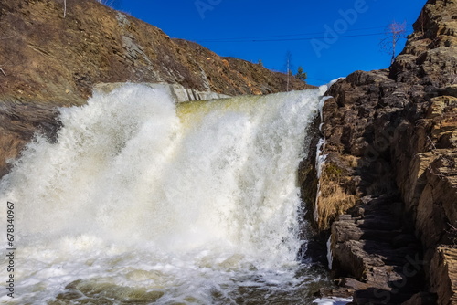 Spring landscape with waterfall on the northern river with stone banks