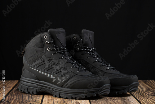 Men's winter boots in black on a dark background.
