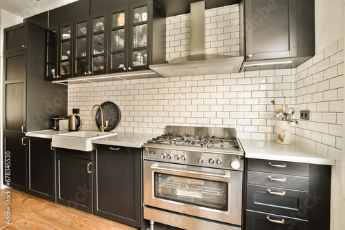 a kitchen with black cabinets and white subway tiles on the wall behind it is an oven, dishwasher and microwave