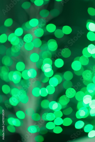 The concept of festive illumination and decoration is a Christmas garland with green bokeh lights