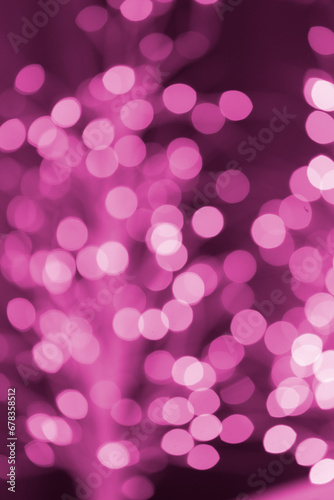 Christmas pink glowing background. Pink festive abstract shiny defocused background with flashing garlands.