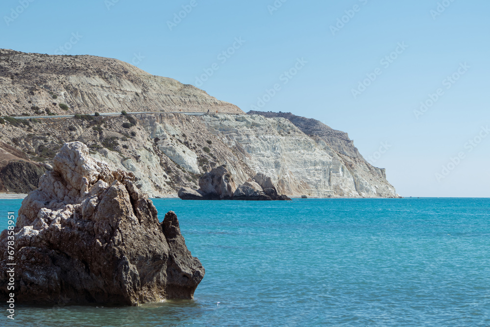 Fototapeta premium Turquoise seascape with a rocky shore. Sunny ocean shore scenery, landscape