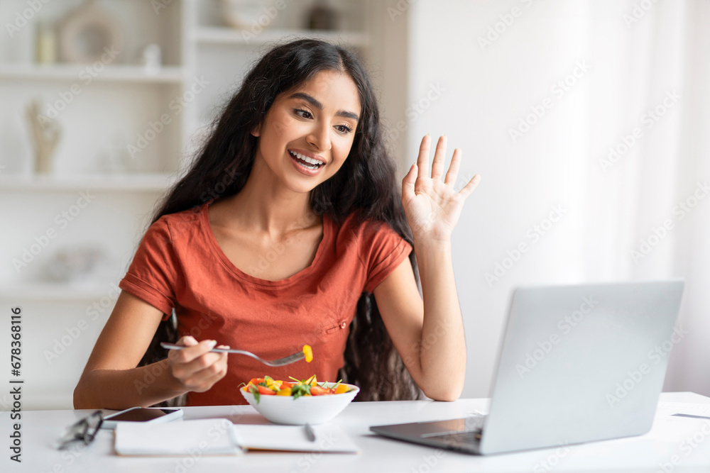 Cheerful millennial indian woman have lunch break at home office Cheerful millennial indian woman have lunch break at home office