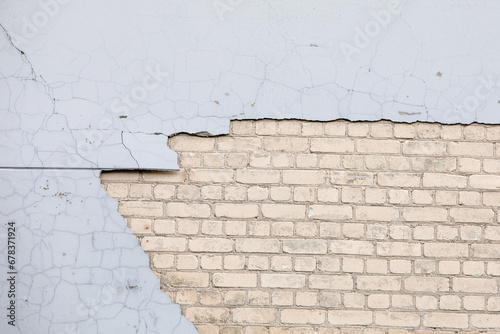 Gray paint and white bricks. Plaster fell from the wall of the house