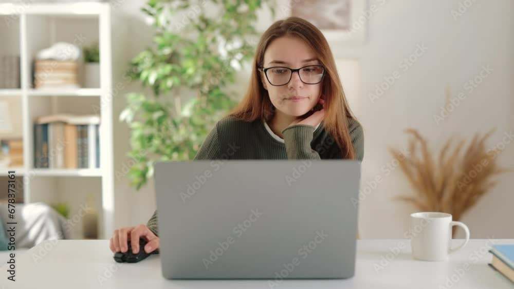 Joyful young businesswoman captured in portrait while engaging in remote work from cozy and comfortable apartment, using laptop Joyful young businesswoman captured in portrait while engaging in remote work from cozy and comfortable apartment, using laptop