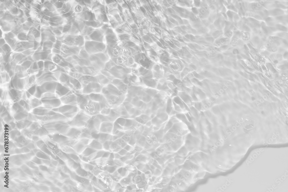 Obraz premium White water with ripples on the surface. Defocus blurred transparent white colored clear calm water surface texture with splashes and bubbles. Water waves with shining pattern texture background.