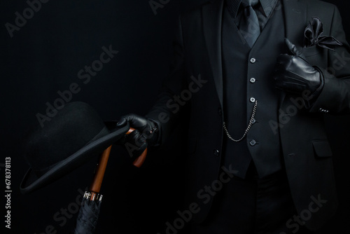 Portrait of British Businessman in Dark Suit Holding Umbrella and Bowler Hat. Mafia Hitman or Gangster. photo