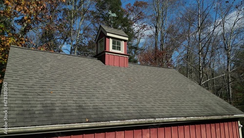 two car garage with cupola aerial footage (drone shot above suburban, rural barn with weather vane) rustic country architecture with shingle roof, small window, skylight, red
