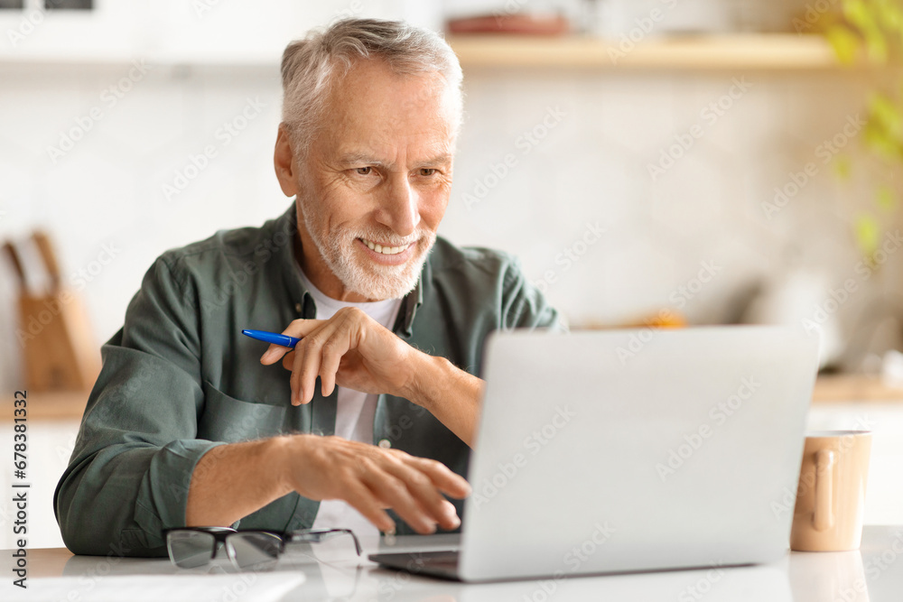 Portrait Of Smiling Senior Man Working On Laptop At Home Portrait Of Smiling Senior Man Working On Laptop At Home