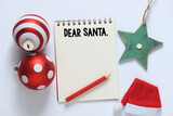 Lettering wish card written to Dear Santa text by kid on white desk with Christmas.