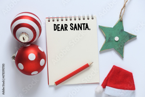 Lettering wish card written to Dear Santa text by kid on white desk with Christmas. photo