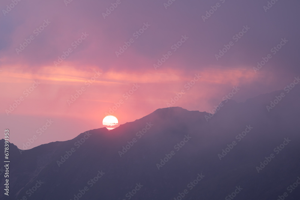 Sunrise over the mountains with dramatic orange sky